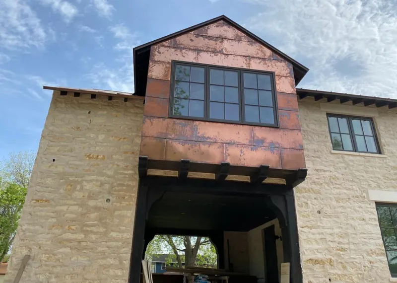 Copper metal panel facade on a stone building for Roof Repair in Ada
